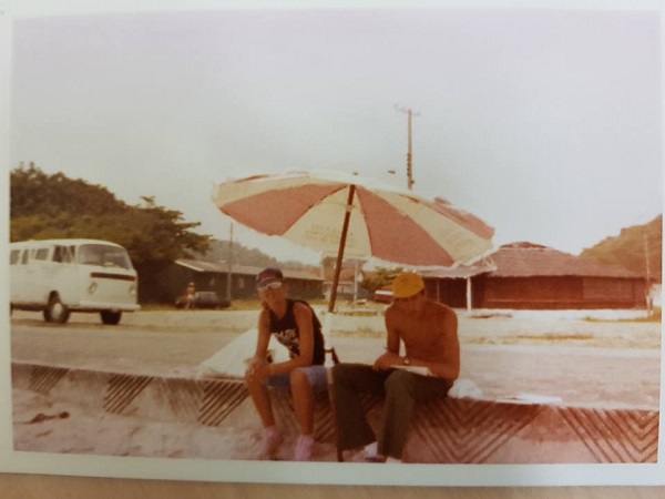 Duas pessoas aproveitam a sombra de um guarda-sol em Guaratuba, 1982