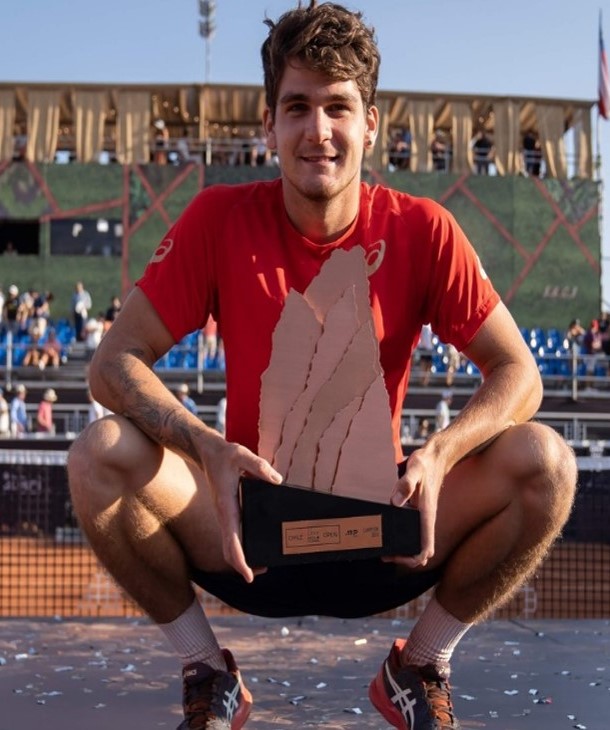 Thiago agachado posa com o troféu