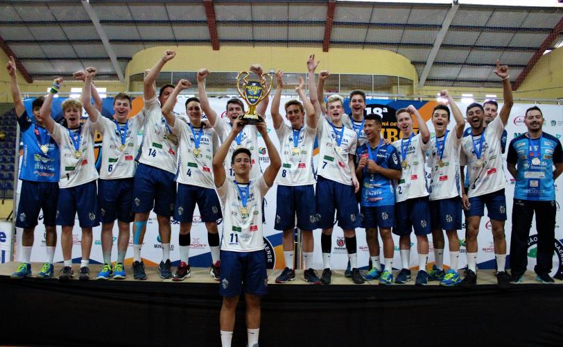 Equipe no pódio levantando o troféu