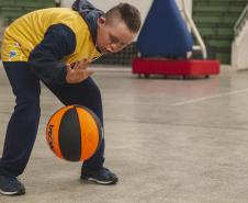 Criança bate bola de basquetebol