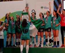 Meninas comemoram no pódio levantando o troféu