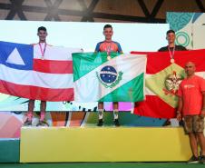 Ciclista no alto do pódio segurando a bandeira