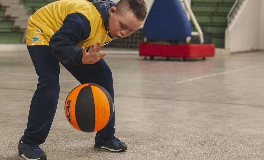 Criança bate bola de basquetebol