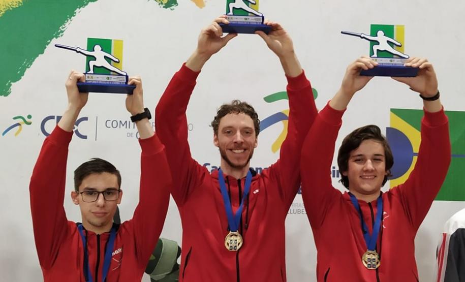 Atletas levantam troféu no pódio