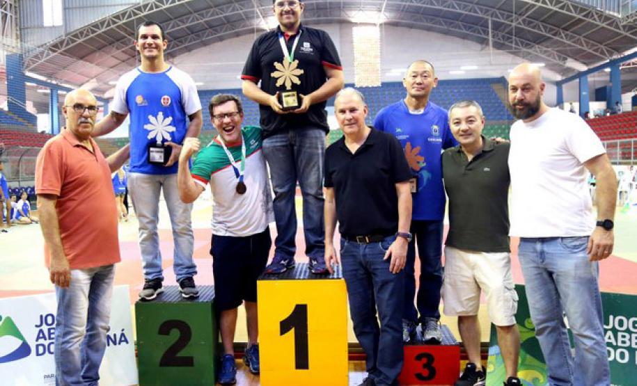 Atletas no pódio recebem troféu