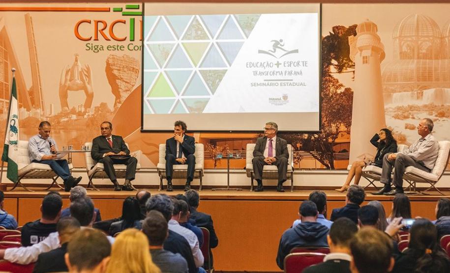 Alguns palestrantes sentados no palco durante debate