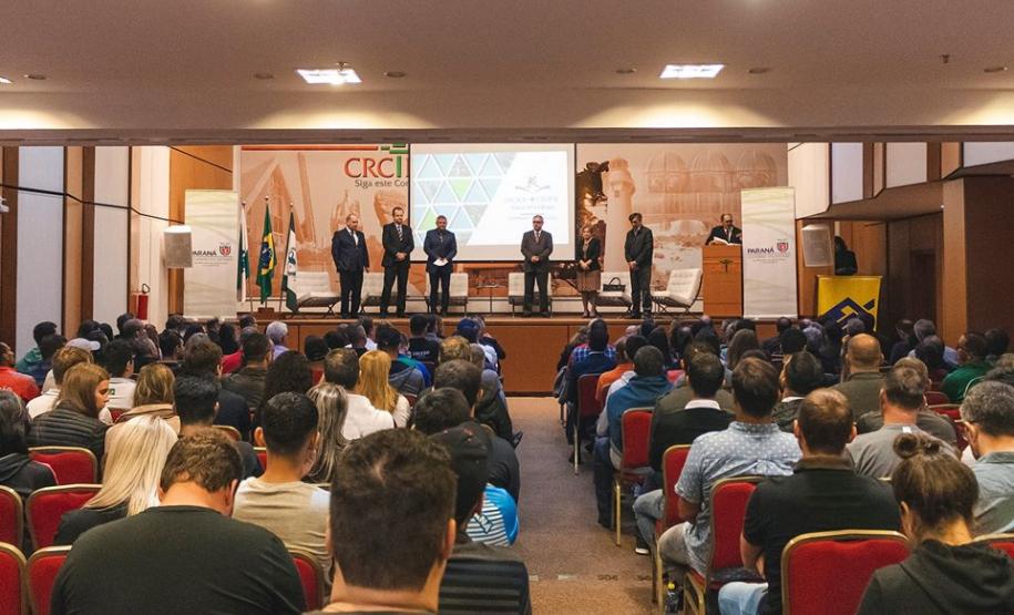 Imagem geral mostrando o palco com as autoridades em pé e o público